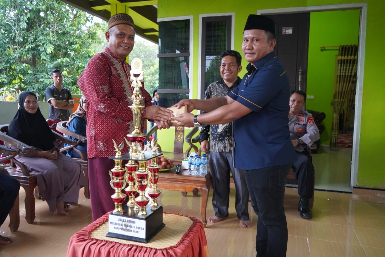 La Ode Darwin saat menyerahkan bonus hadiah kepada perwakilan Kafilah Kecamatan Kusambi yang berhasil meraih juara umum pada MTQ ke-V Kabupaten Muna Barat