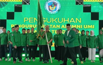 Ruksamin saat menerima bendera pataka pengurus IKA UMI Sultra